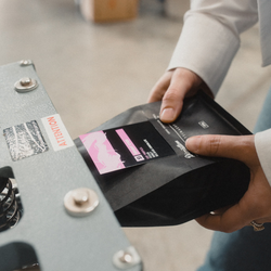 A close up of someone heat-sealing a bag of Bright Eyes coffee