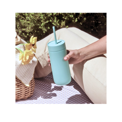 Fellow Carter Mug with straw and held by hand