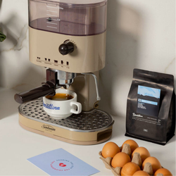 Fresh coffee under an espresso machine with a bag of Dimattina coffee beside it