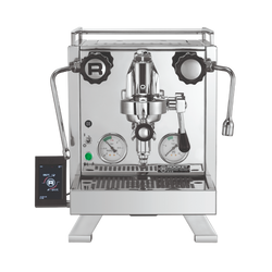 A silver Rocket Espresso Cinquantotto espresso machine with dual boilers, a touch screen communication pod, and a brass grouphead.