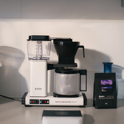 A bag of Ronnie's by Dimattina Coffee next to a Moccamaster on a kitchen bench