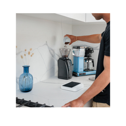 Man pours coffee beans into Baratza Encore