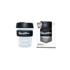 A clear glass KeepCup with a black rubber band and lid, alongside its packaging box which reads 'Dimattina BREW'.