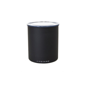 A black Airscape canister, a cylindrical kitchen appliance designed to keep coffee fresh by actively pushing air out.